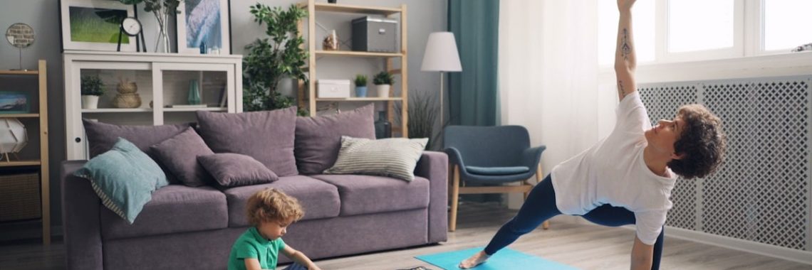 a woman and a child doing yoga in a living room